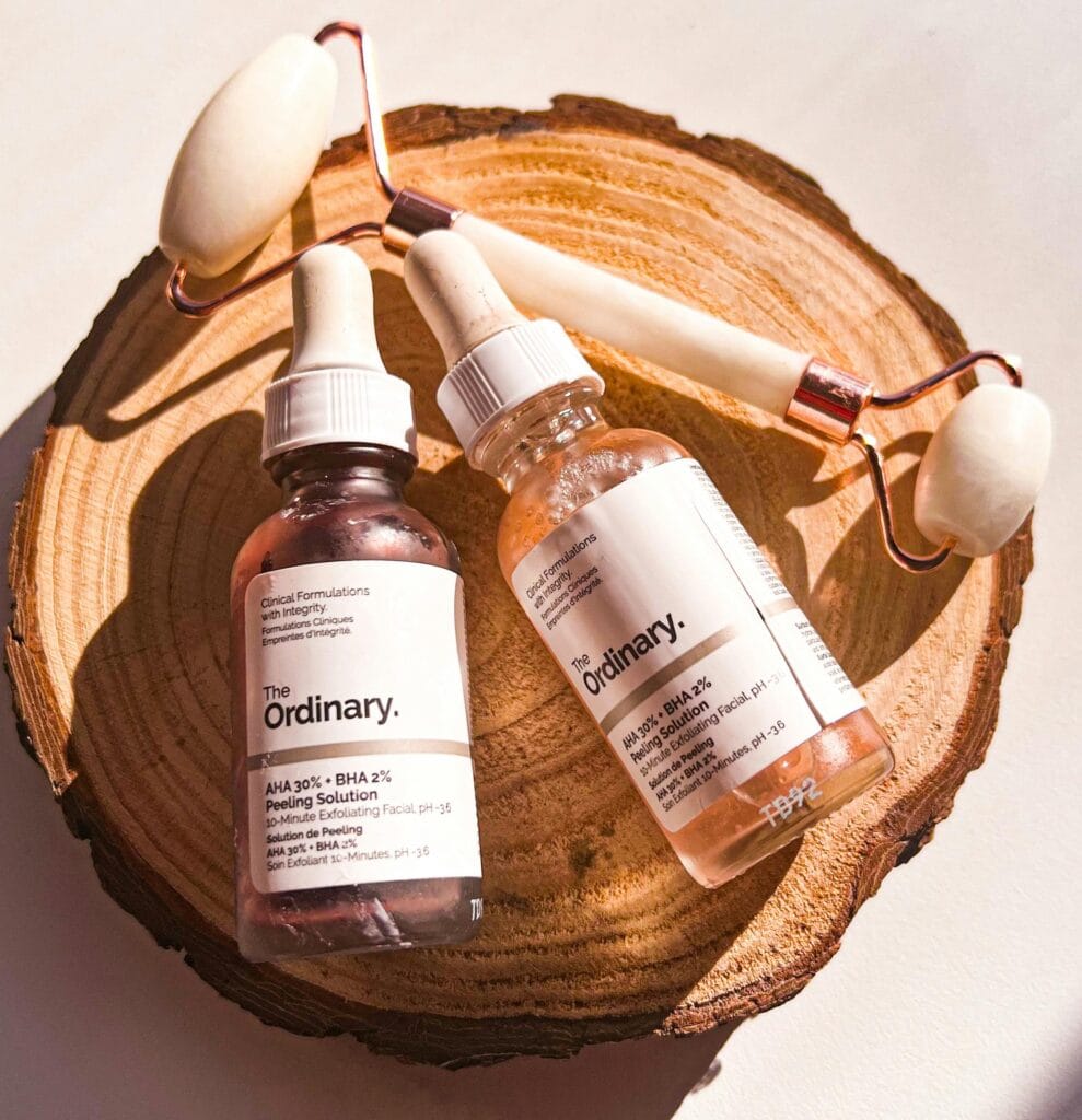 The Ordinary AHA 30% BHA 2% Peeling Solution with face roller on wooden background